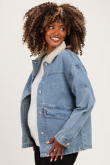 woman wearing a light blue denim maternity jacket over a white top and showing her baby bump
