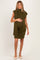 woman wearing an olive green maternity dress with a shawl collar and a fitted style, highlighting her baby bump