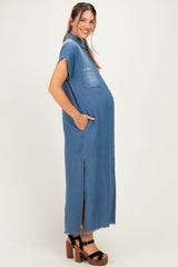woman wearing a blue denim maternity dress with short sleeves, side pockets, and a front slit, showcasing her baby bump