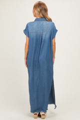 woman wearing a long denim shirt dress with short sleeves and high side slits, showing the back view