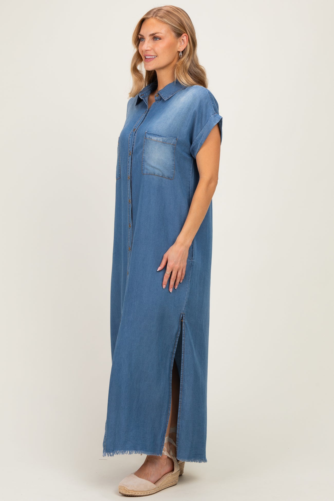 woman wearing a light blue denim maxi shirt dress with short sleeves and a front pocket