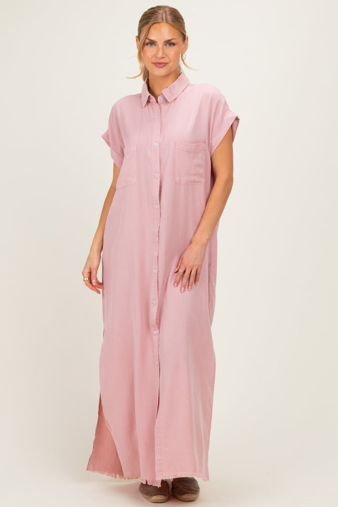 woman wearing a pink maxi shirt dress with short sleeves and front pockets, standing against a neutral background