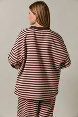 woman wearing a brown and pink striped oversized sweatshirt, viewed from the back