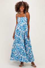 woman wearing a blue and white floral maternity maxi dress with thin straps and a flowy silhouette