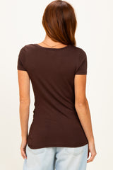woman wearing a fitted brown short sleeve top with ruching details at the sides