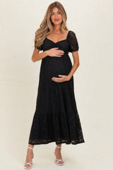 woman wearing a black lace maternity dress with short puff sleeves and a baby bump