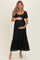woman wearing a black lace maternity dress with short puff sleeves and a baby bump