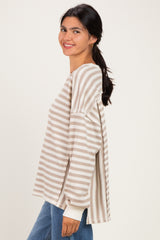 woman wearing a beige and white striped long sleeve top with a relaxed fit and side slits, smiling sideways