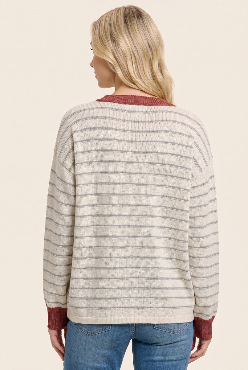 woman wearing a cream and gray striped sweater with a maroon collar, viewed from the back, paired with blue jeans