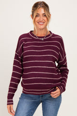 woman wearing a maroon striped maternity sweater with a relaxed fit and scoop neckline, smiling at the camera