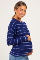 woman wearing a navy blue striped maternity sweater and cradling her baby bump