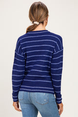 woman wearing a navy blue striped maternity sweater with a relaxed fit and ribbed details, seen from the back