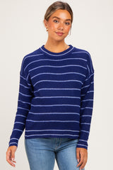woman wearing a navy blue striped maternity sweater paired with light denim jeans