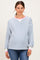 woman wearing a striped light blue and white maternity sweatshirt with pink cuffs and a visible baby bump