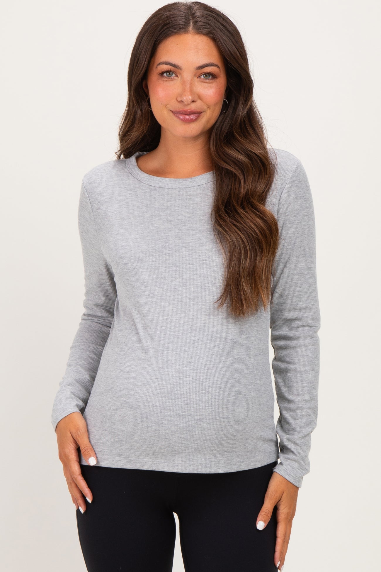 woman wearing a gray long sleeve maternity top and showing her baby bump