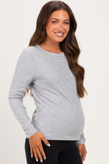 woman wearing a gray long sleeve maternity top and showing her baby bump