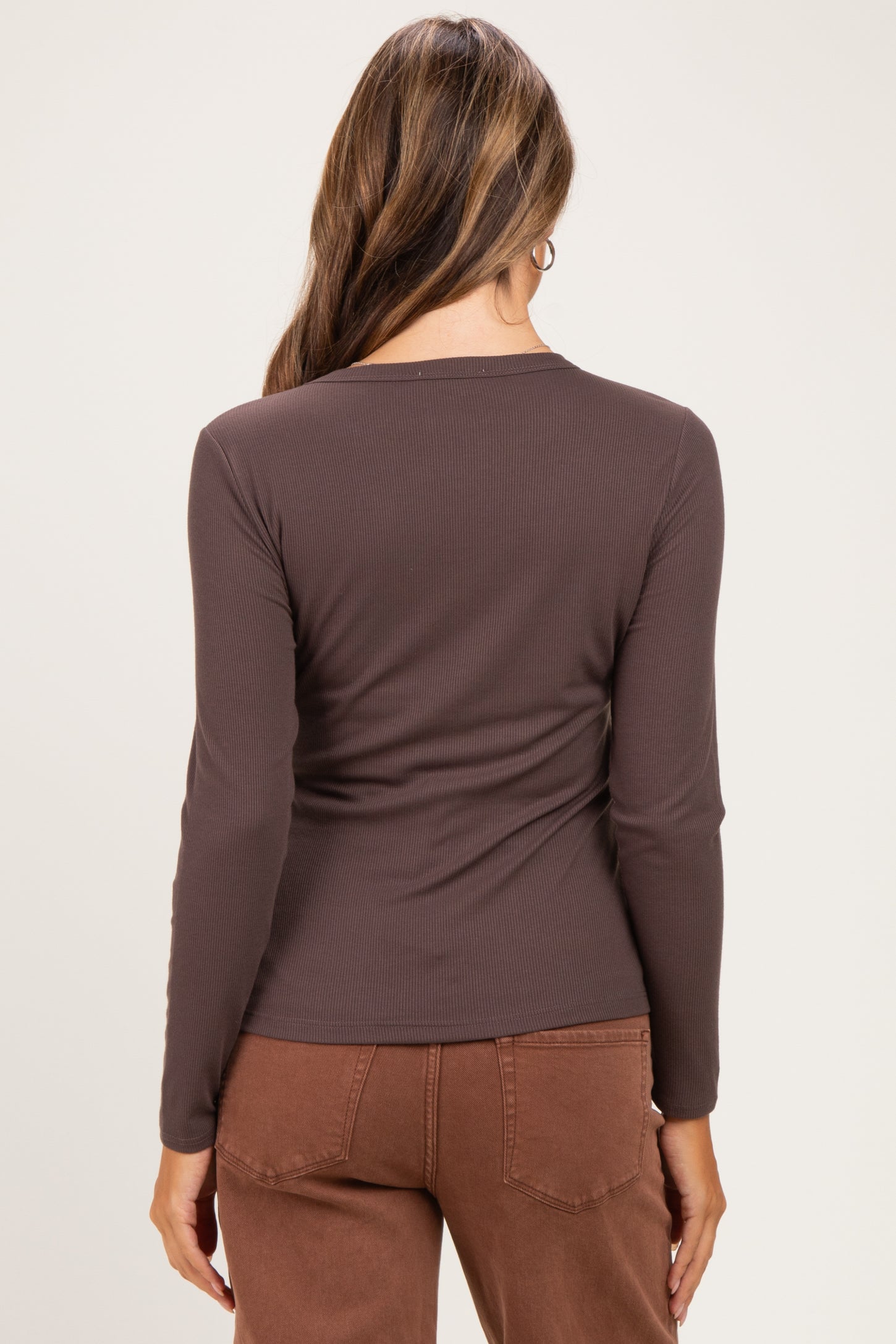 woman wearing a dark brown long sleeve maternity top, view of the back