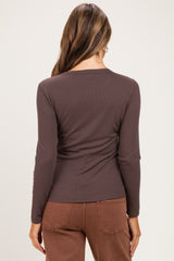 woman wearing a dark brown long sleeve maternity top, view of the back