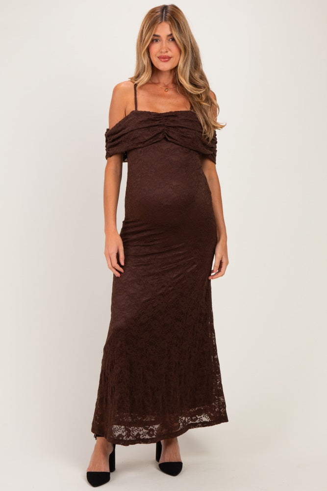 woman wearing a brown lace maternity maxi dress with off-the-shoulder straps and a fitted silhouette, showing her baby bump