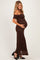 woman wearing a brown off-the-shoulder lace maternity dress and holding her baby bump