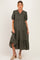 woman wearing a dark green floral maternity dress with short puff sleeves and tiered skirt, showcasing her baby bump