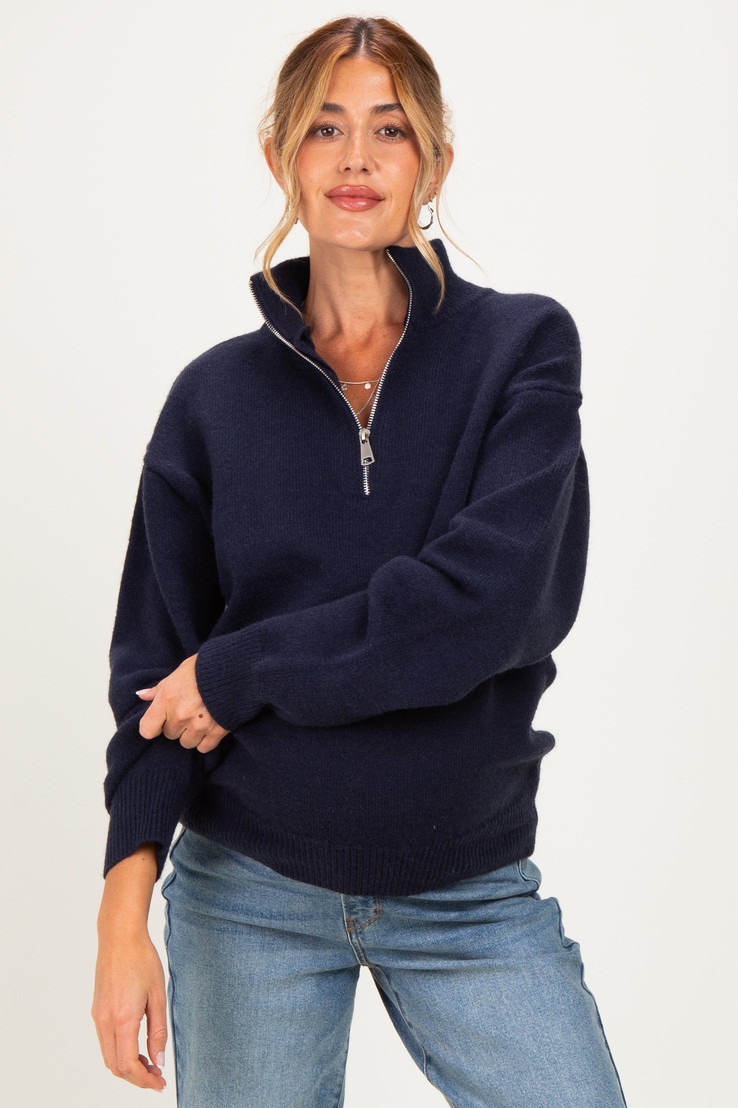 woman wearing a navy blue zip-up maternity sweater with a relaxed fit and a high collar