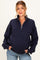 woman wearing a navy blue maternity quarter-zip sweater with a relaxed fit and holding her baby bump