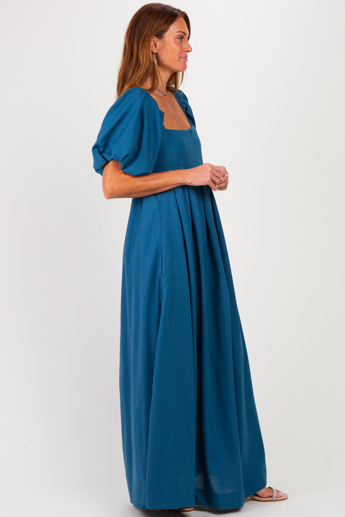 woman wearing a teal maxi dress with puff sleeves and a square neckline