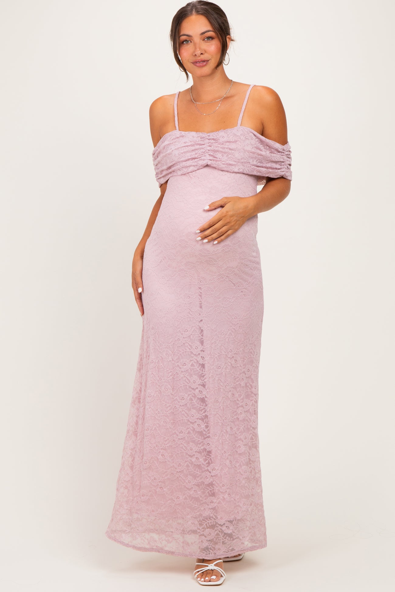 woman wearing a light purple lace maternity gown with off-shoulder design and a visible baby bump