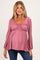 woman wearing a mauve maternity top with a square neckline and long sleeves, showcasing her baby bump