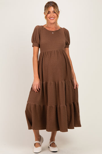woman wearing a brown tiered maternity dress with short puff sleeves and a visible baby bump