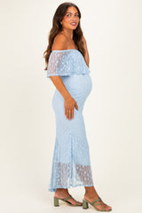 woman wearing a light blue off-shoulder maternity dress with a layered design and a visible baby bump
