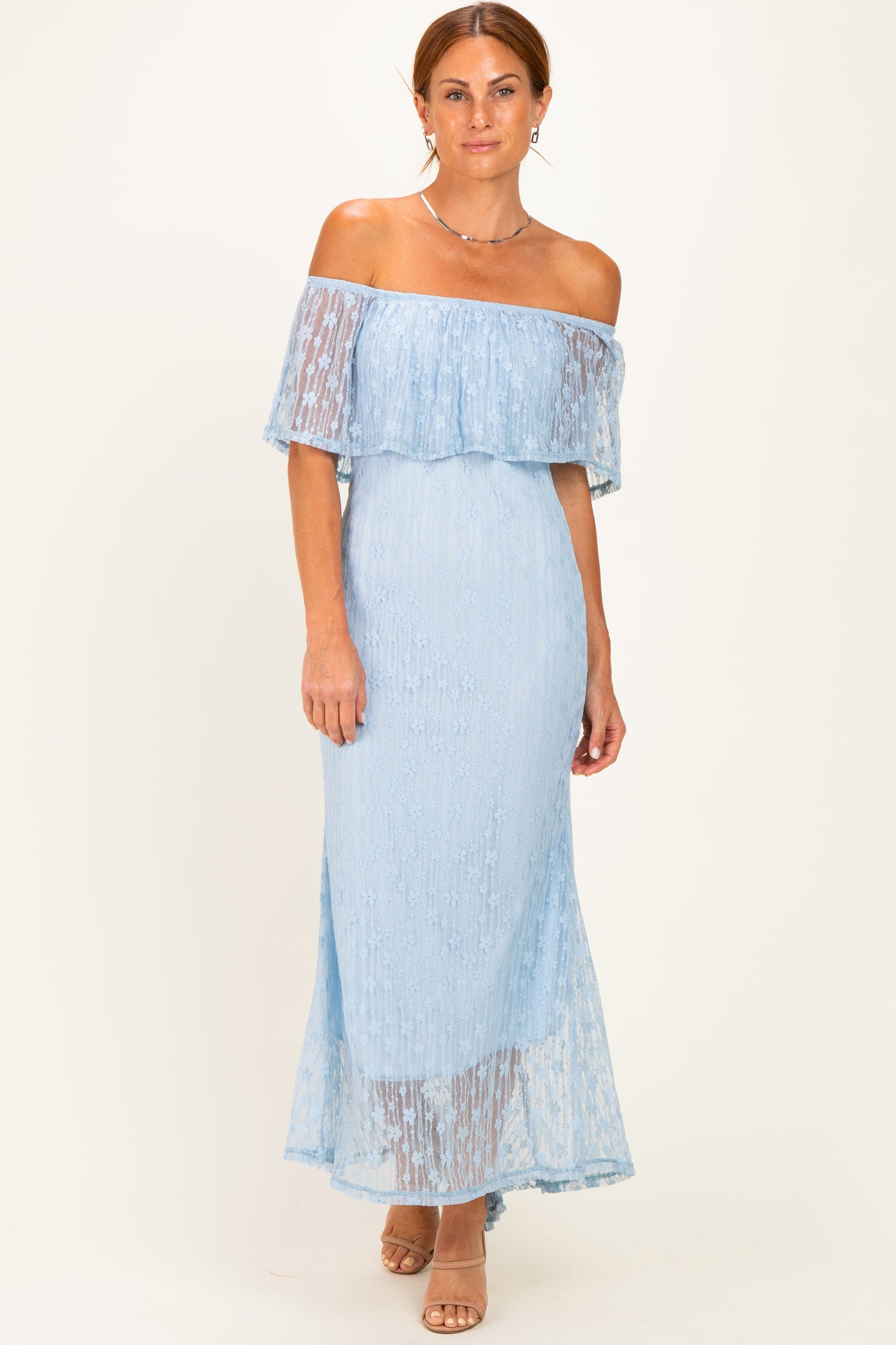 woman wearing a light blue off-the-shoulder lace maxi dress with a flowy skirt and fitted bodice