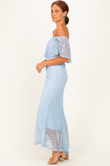 woman wearing a light blue off-shoulder maxi dress with lace details and a flowy hemline