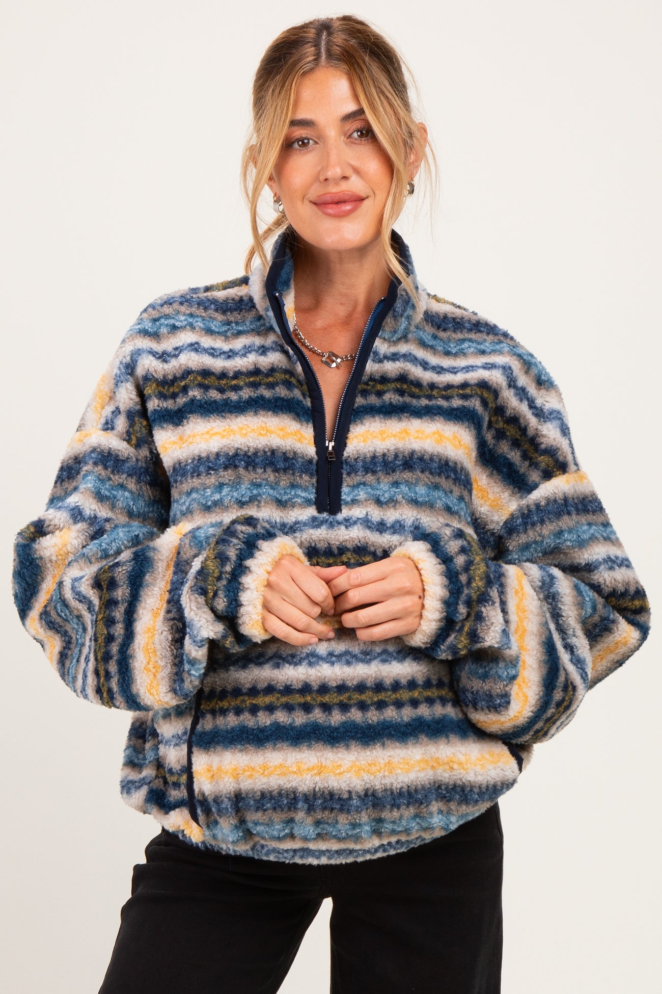 woman wearing a multicolored striped fleece maternity pullover with a half zipper and cozy fit