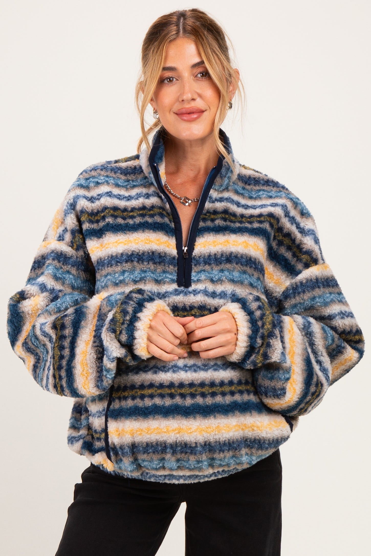 woman wearing a multicolored striped fleece maternity pullover with a half zipper and cozy fit