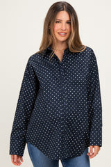 woman wearing a navy maternity button-up shirt with white polka dots and a visible baby bump