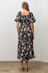 woman wearing a black floral midi dress with puff sleeves and a smocked back view