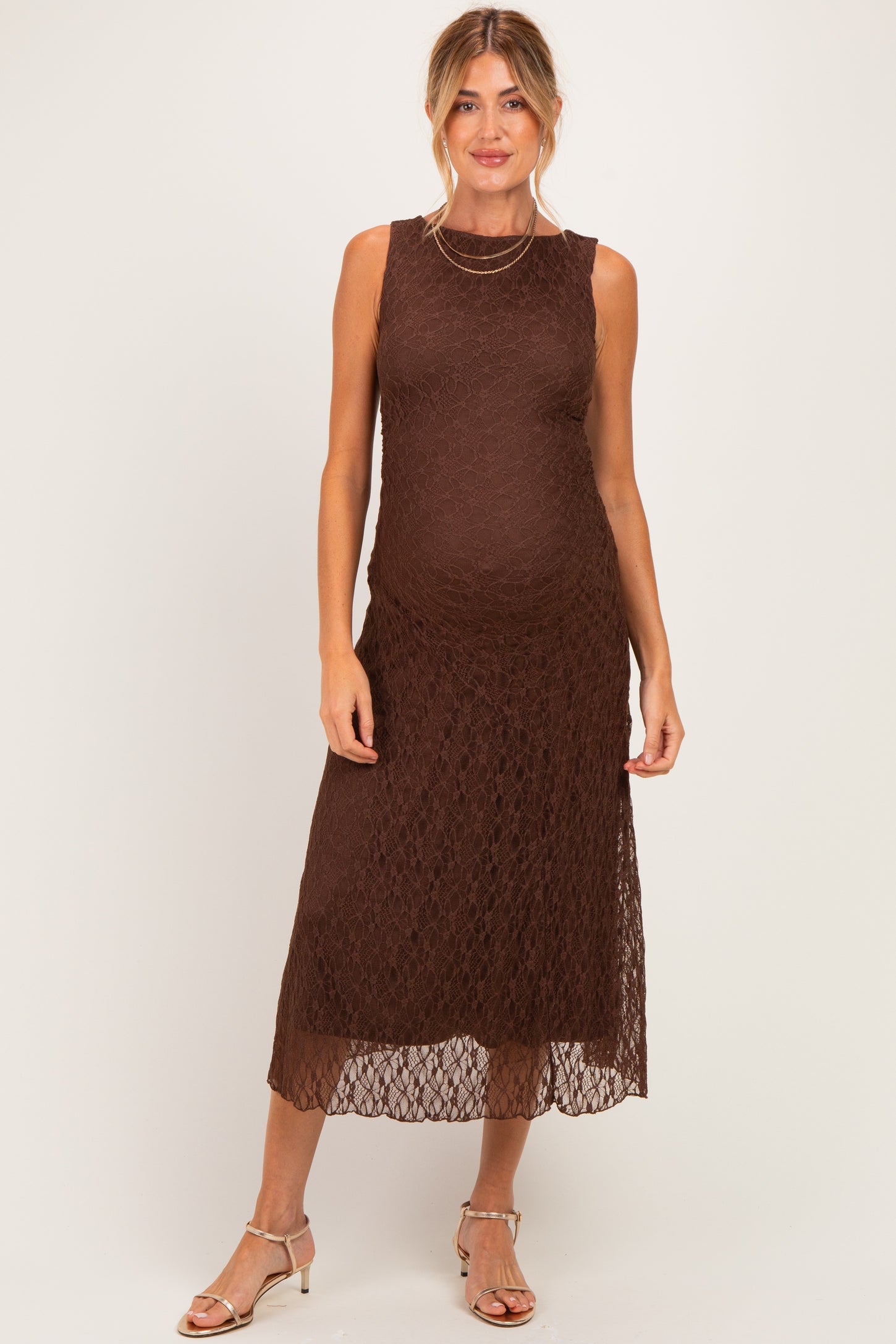 woman wearing a brown lace midi maternity dress showcasing her baby bump