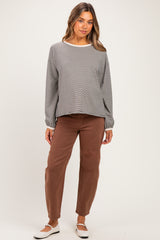 woman wearing a gray striped long sleeve maternity top and brown maternity pants with a relaxed fit