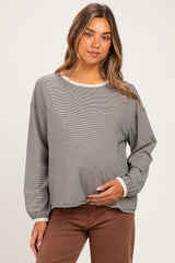 woman wearing a gray striped maternity top with long sleeves and a relaxed fit, holding her baby bump