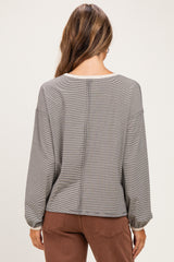 woman wearing a gray striped long sleeve maternity top, showing the back view with gathered sleeves