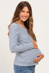 woman wearing a navy and white striped maternity top and holding her baby bump