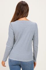 woman wearing a navy and white striped long sleeve maternity top, showing the back view with a fitted silhouette