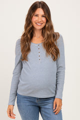 woman wearing a blue and white striped maternity top with buttons and a visible baby bump