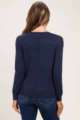 woman wearing a navy blue maternity sweater with long sleeves and a relaxed fit, seen from the back