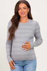 woman wearing a gray striped maternity sweater and holding her baby bump