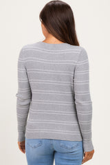 woman wearing a gray striped maternity sweater, viewing from the back, paired with blue jeans