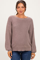 woman wearing a mauve maternity sweater with a relaxed fit and long sleeves, styled with blue jeans