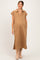 woman wearing a tan maternity dress with a collar and side pockets, showcasing her baby bump